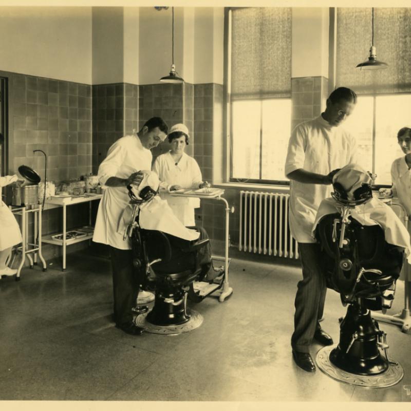 Dr. Henry S. Dunning, D.D.S. (C), with another doctor and dental hygienists, treating patients in the School of Dental and Oral Surgery unit of the Vanderbilt Clinic